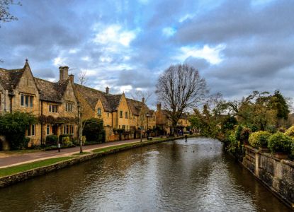 Casa típica inglesa y arroyo en la región de las Cotswolds